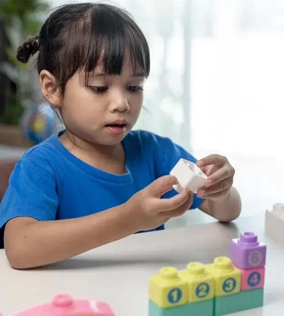 A young child concentrating on a stacking activity